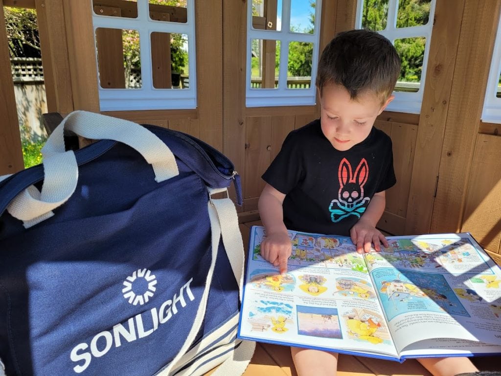 Pre-kindergartener looking at Sonlight's books from Exploring God's World