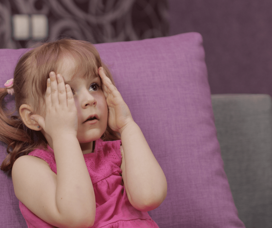little girls covering her eyes to watch movie